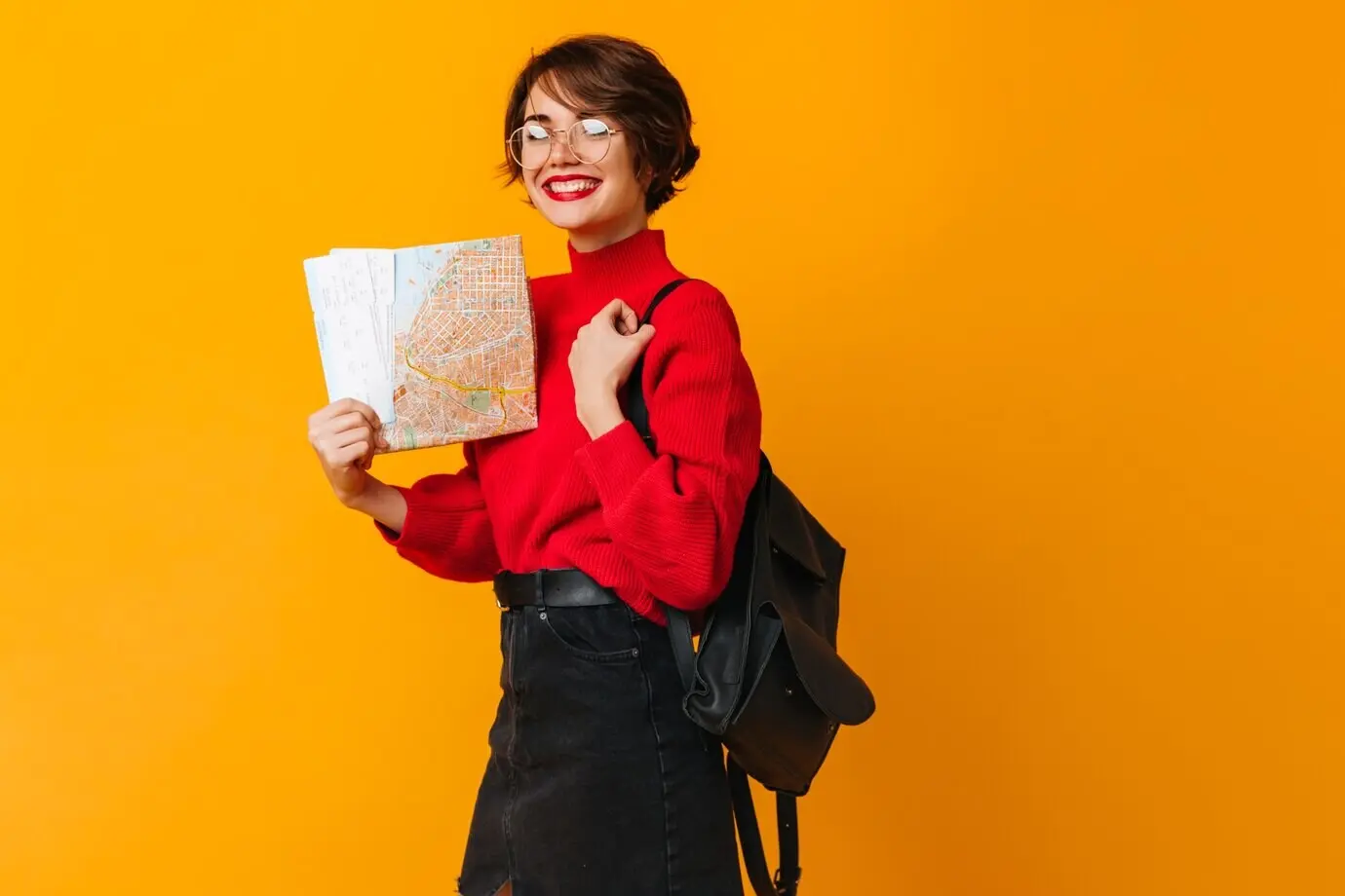 Modelo femenina alegre sosteniendo un mapa de la ciudad.