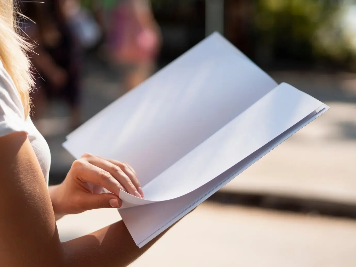 Primer plano de una mujer sosteniendo una maqueta de revista.